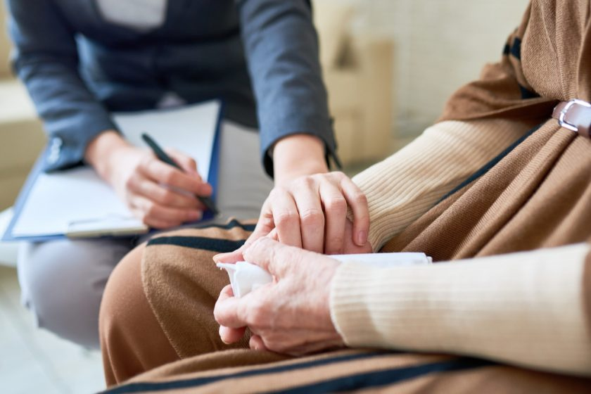 A female therapist from mental health services holding the hand of her client